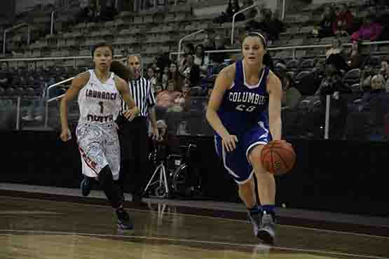 Senior Paige Littrell runs down the court towards the opposing teams basket while guarding the ball.